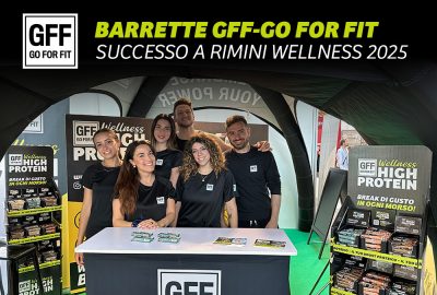 Team GFF allo stand di Rimini Wellness 2025 con barrette proteiche GO FOR FIT esposte e materiale promozionale.