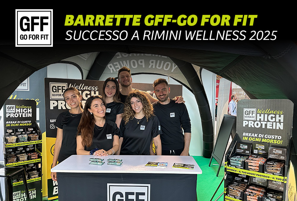 Team GFF allo stand di Rimini Wellness 2025 con barrette proteiche GO FOR FIT esposte e materiale promozionale.